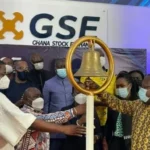 Ghana Stock Exchange trading floor showing rising stock charts and financial data, highlighting strong dollar gains driven by oil and banking sector rally amid global market selloff.