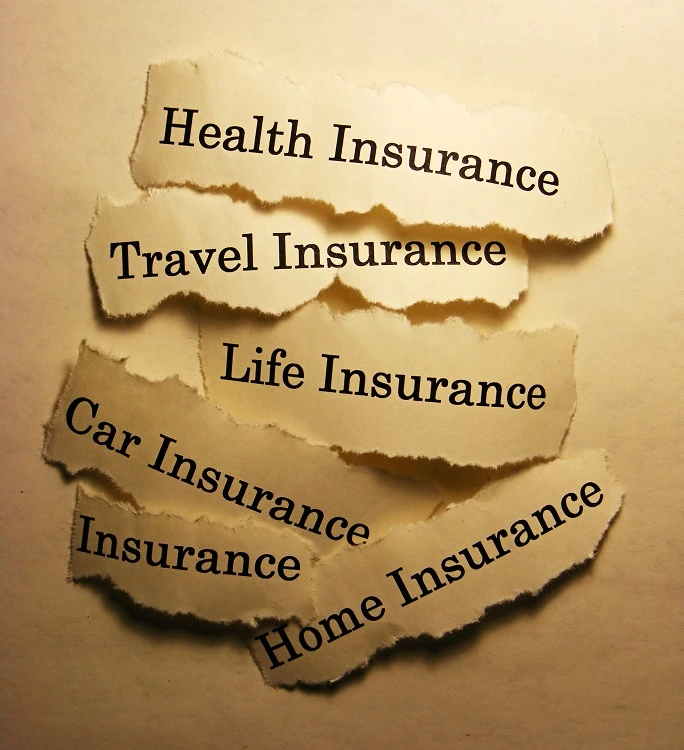 Torn paper labels showing health insurance, travel insurance, life insurance, car insurance, and home insurance, representing insurance products and policyholder protection.