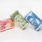 Rolled Nigerian naira banknotes on a white background, representing FGN Savings Bonds, naira income, and local-currency fixed-income investing.