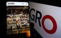 Phone showing the SEGRO website in front of SEGRO branding, representing the company’s logistics real estate business and takeover bid discussions.