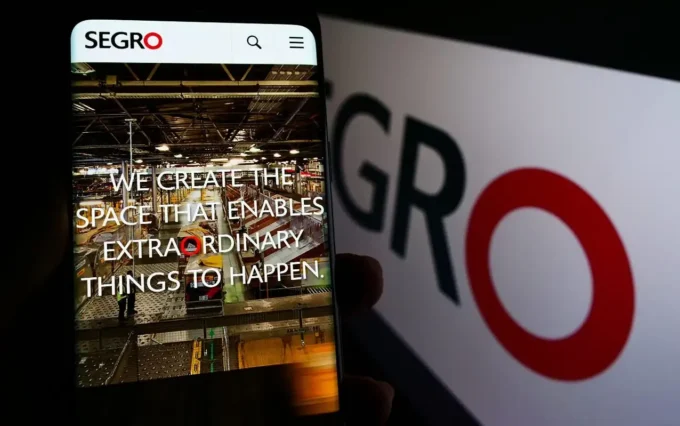 Phone showing the SEGRO website in front of SEGRO branding, representing the company’s logistics real estate business and takeover bid discussions.