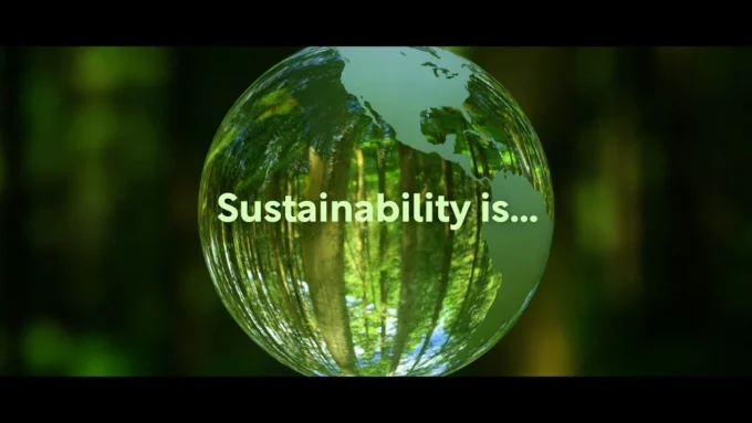 Glass globe reflecting a forest with the words “Sustainability is,” representing sustainability bonds, green finance, and environmental investment themes.
