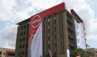 Photo of an Absa-branded office building with a large red Absa logo panel on the front facade. The image shows the bank’s corporate presence and is used to illustrate Absa Group’s planned sale of controlling stakes in First Assurance and Absa Life Assurance Kenya, while maintaining insurance distribution through Absa Bank Kenya.