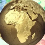 A gold globe focused on Africa placed over colourful African banknotes, representing African sovereign debt, regional capital markets, currency exposure and investment flows into African government bonds.