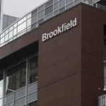 Exterior view of a modern office building with Brookfield signage on a brown façade, representing institutional asset management, real estate investment, infrastructure finance and property-linked investment activity.