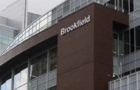 Exterior view of a modern office building with Brookfield signage on a brown façade, representing institutional asset management, real estate investment, infrastructure finance and property-linked investment activity.