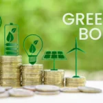 Green bond concept image showing stacks of coins with renewable energy icons, including a light bulb, battery, solar panel and wind turbine, used to illustrate sustainable finance, green bonds and environmental project funding.