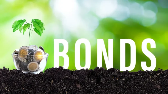 Image of coins in a glass container with a small green plant growing from them, placed in soil against a blurred green background. Large white text reads “BONDS,” symbolising green bonds, sustainable finance and investment in environmental projects.
