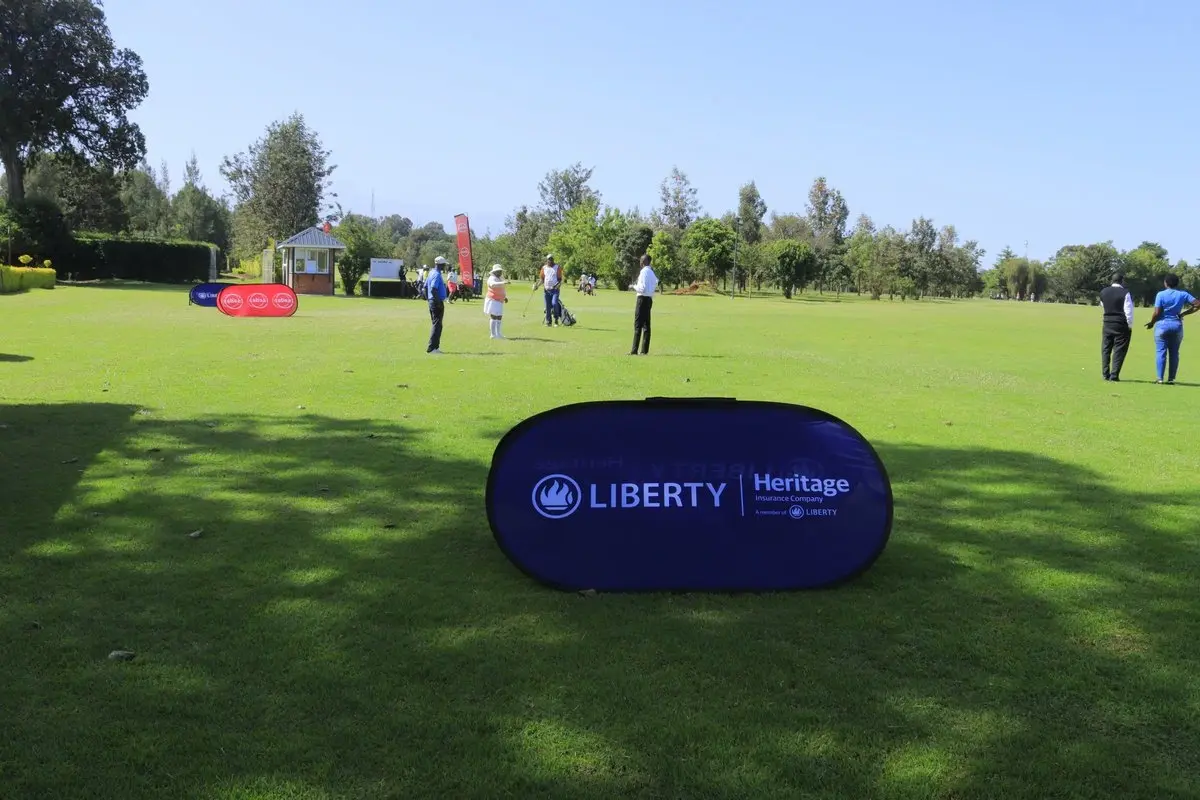 Article image showing a golf course in Kenya with a Liberty and Heritage Insurance branded sign in the foreground and several people standing on the course in the distance. The image represents Liberty Kenya’s insurance brand presence and can be used as a contextual visual for an article about Liberty Kenya, LifeVest, investment-linked insurance and policyholder protection.