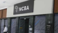 Exterior image of an NCBA branch entrance with the NCBA logo displayed above the doorway, representing the Kenyan banking group’s financial results, dividend announcement and investor outlook.