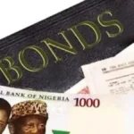 Image showing Nigerian naira notes and a document marked “Bonds,” representing Nigeria’s Federal Government bond market, naira-denominated sovereign debt, auction demand, fixed-income investing and government borrowing.