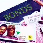 Article image showing Nigerian naira notes placed next to a bond document. The image represents Nigeria’s Federal Government bond market, naira-denominated debt, sovereign borrowing and fixed-income investment.