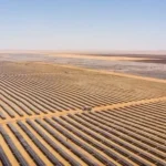 Aerial view of a large solar farm stretching across a desert landscape, used to illustrate renewable energy financing, solar infrastructure, Scatec’s green bond roadshow and investor interest in green bonds.