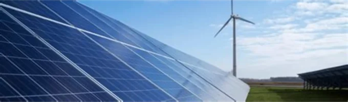 Solar panels in the foreground with a wind turbine in the background under a blue sky, representing renewable energy, clean-power infrastructure, climate finance and green-bond investment projects.