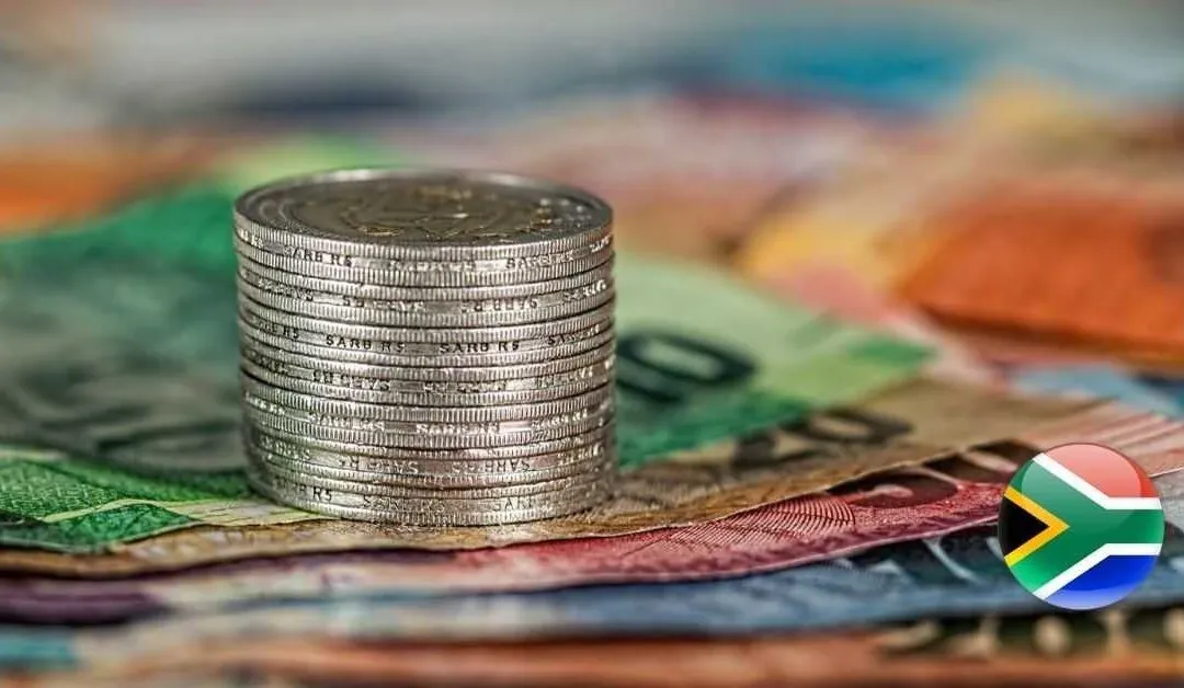 Close-up image of stacked coins on South African rand banknotes with a South African flag icon, representing South African government bonds, rand-denominated fixed income, falling yields and investor focus on bond-market pricing.