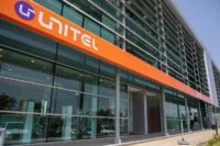 Exterior view of a Unitel building with orange Unitel branding across a glass-fronted office façade in Angola.