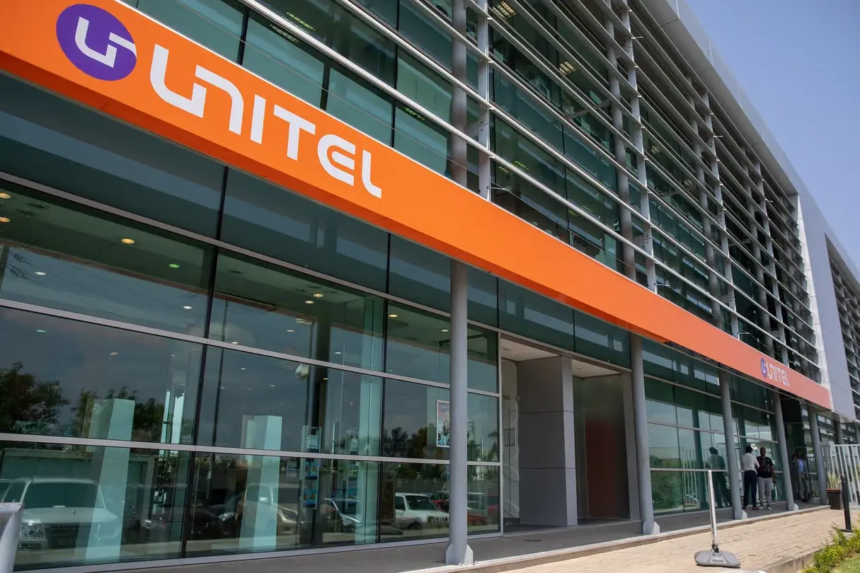 Exterior view of a Unitel building with orange Unitel branding across a glass-fronted office façade in Angola.