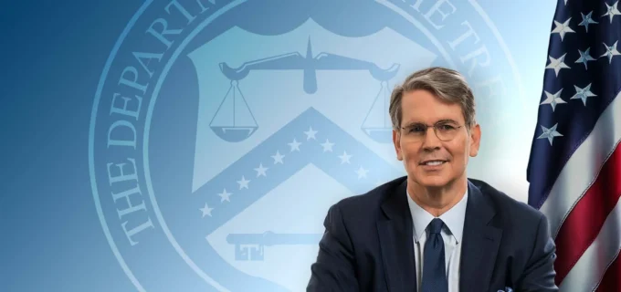 Article image showing a senior U.S. Treasury official in front of a Treasury-themed background and an American flag. The image represents U.S. financial regulation, stablecoin supervision, GENIUS Act implementation, Treasury rulemaking and digital-asset licensing.