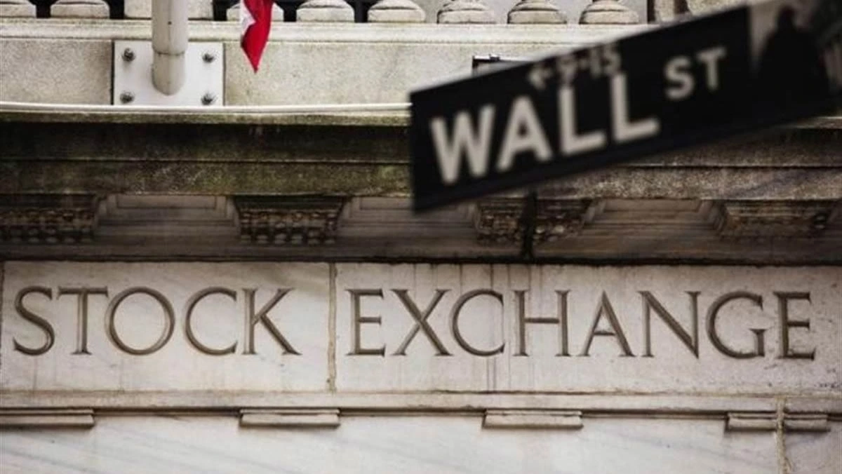 Article image showing the New York Stock Exchange building with a Wall Street sign in the foreground. The image represents U.S. equity markets, Wall Street trading sentiment and investor focus on the S&P 500 near record levels.